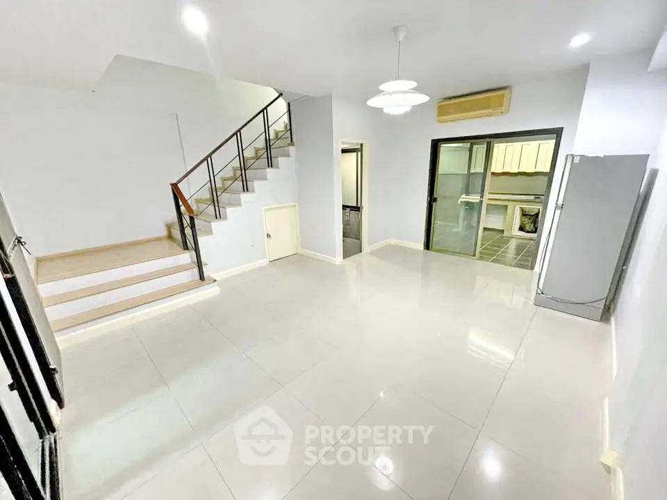 Spacious modern living room with sleek staircase and open layout, perfect for contemporary living.