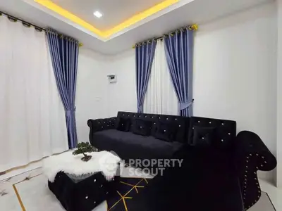 Elegant living room with plush black sofa and stylish blue curtains
