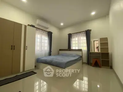 Spacious bedroom with modern furnishings and natural light