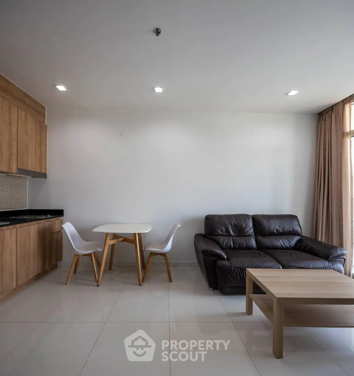 Modern living room with sleek furniture and open kitchen layout in a stylish apartment.