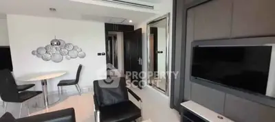 Modern living room with sleek black furniture and wall-mounted TV in a stylish apartment.