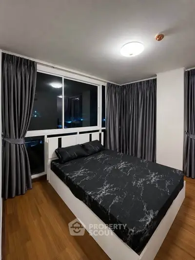 Modern bedroom with stylish black marble bedding and floor-to-ceiling windows for a cozy urban retreat.