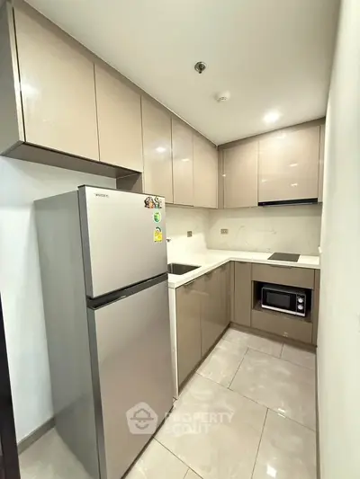 Modern kitchen with sleek cabinetry and stainless steel appliances in a compact layout.