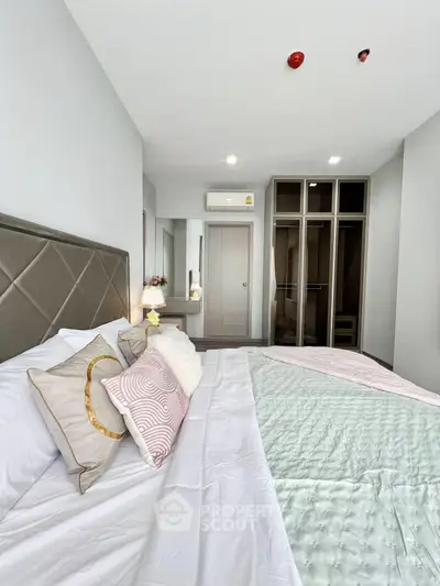 Modern bedroom with stylish decor and ample closet space in a contemporary apartment.