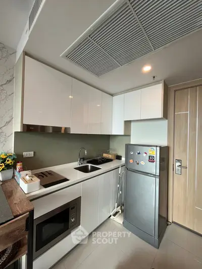 Modern compact kitchen with sleek cabinetry and stainless steel appliances