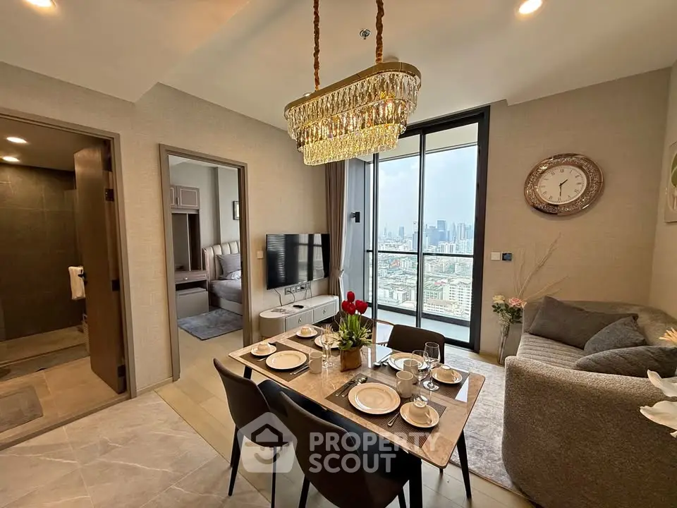 Luxurious dining area with city view, elegant chandelier, and modern decor in a high-rise apartment.