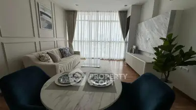 Modern living room with elegant decor and large windows offering natural light.