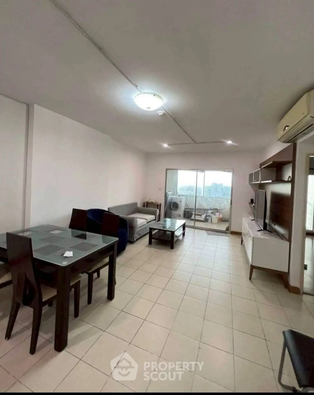 Spacious living room with modern furniture and balcony view, ideal for urban living.