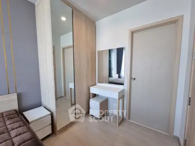 Modern bedroom with stylish furniture and large mirrored wardrobe