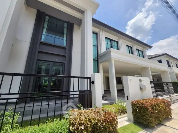 Modern townhouse exterior with sleek design and lush landscaping