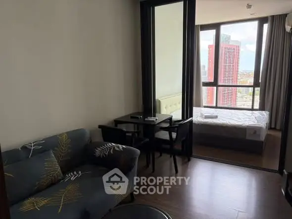 Modern apartment with cozy living area and bedroom, featuring large windows and stylish furnishings.