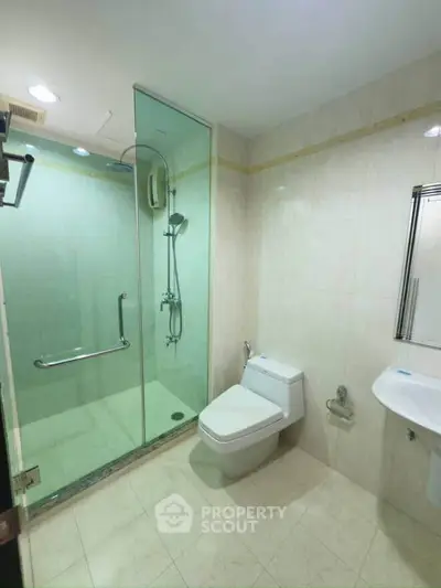 Modern bathroom with glass shower and sleek fixtures in a contemporary home.