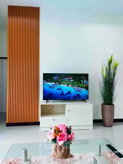 Modern living room with sleek TV stand, decorative plants, and stylish wall paneling.