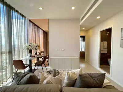 Luxurious modern living room with floor-to-ceiling windows and elegant dining area