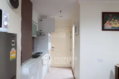 Compact kitchen with modern appliances and white cabinetry