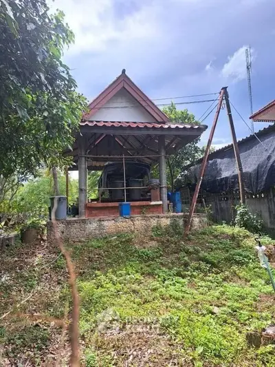 Charming rustic outdoor structure with traditional roof in lush garden setting.
