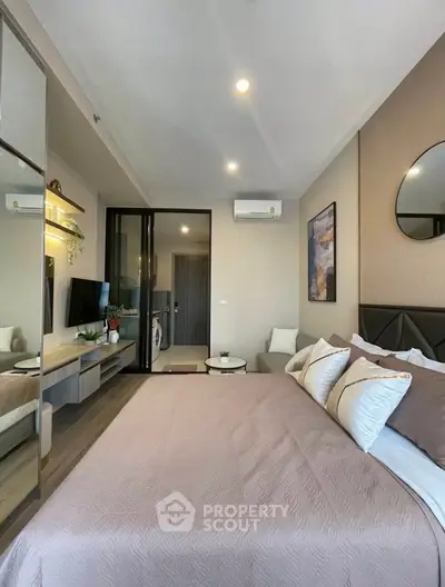 Modern bedroom with stylish decor and mirrored wardrobe in a cozy apartment.