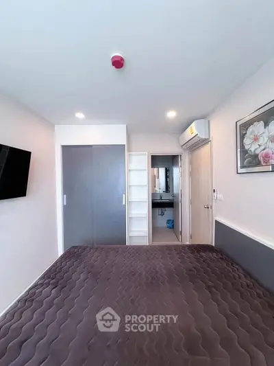 Modern bedroom with sleek design, featuring built-in wardrobe and air conditioning, perfect for comfort and style.