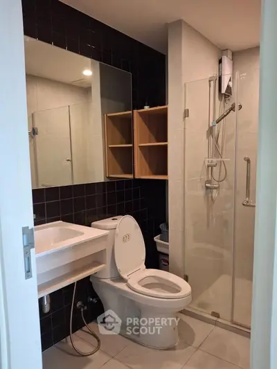 Modern bathroom with glass shower and sleek fixtures in a contemporary home.