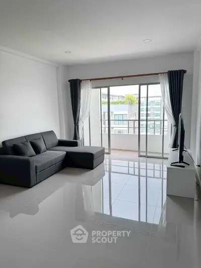 Spacious modern living room with sleek sofa and balcony view