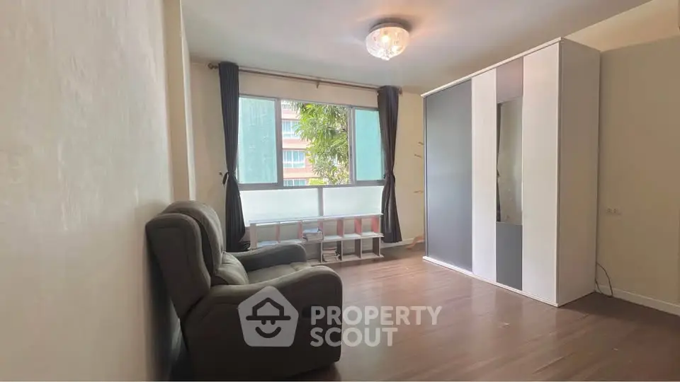 Spacious living room with modern decor and large window for natural light.