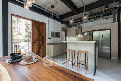 Modern kitchen with open layout, stylish lighting, and wooden accents in a contemporary home.