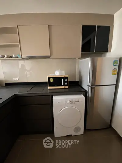 Modern kitchen with sleek cabinets, stainless steel fridge, and built-in appliances.
