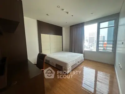 Spacious bedroom with city view and wooden flooring