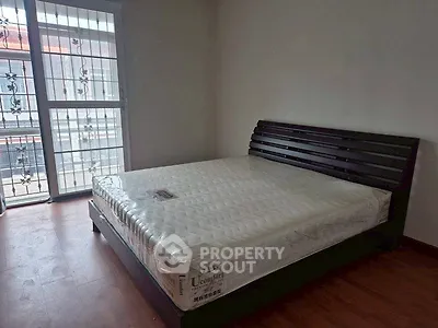 Spacious bedroom with large window and modern bed frame, perfect for natural light lovers.