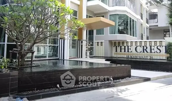 Modern condominium entrance with sleek design and water feature at The Crest Sukhumvit 34.