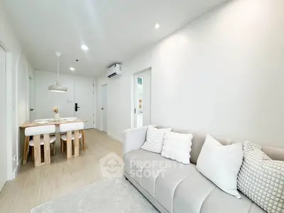 Modern living room with cozy sofa and dining area in a bright, minimalist apartment.