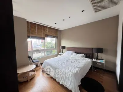 Spacious bedroom with city view, featuring a comfortable bed and modern decor.