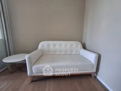 Modern minimalist living room with white sofa and side table, perfect for cozy relaxation.
