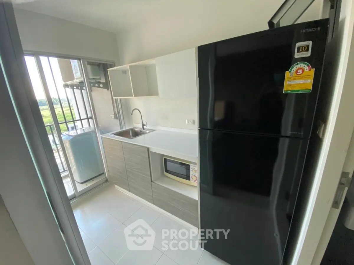 Modern kitchen with sleek appliances and balcony view