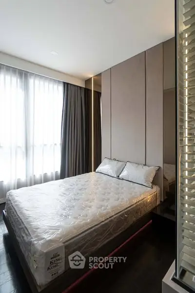 Modern bedroom with large windows and stylish decor, featuring a comfortable King Koil mattress.