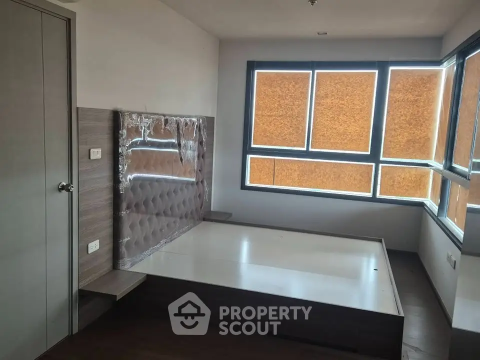 Modern bedroom with large windows and built-in bed frame, perfect for urban living.