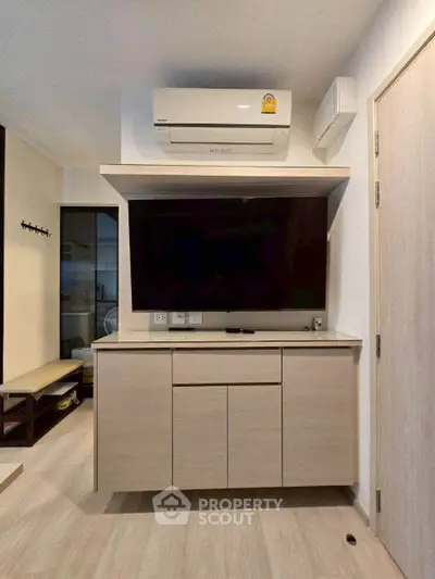 Modern living room with sleek TV cabinet and air conditioning unit, perfect for comfortable living.