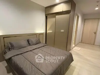 Modern bedroom with sleek wardrobe and cozy bedding in a stylish apartment.