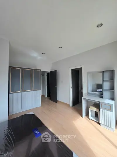 Bright bedroom with modern furniture and ample natural light, showcasing a sleek design and spacious layout.