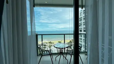 Stunning beachfront balcony view with ocean and sky panorama from modern apartment.