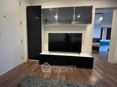 Modern living room with sleek black entertainment center and hardwood floors