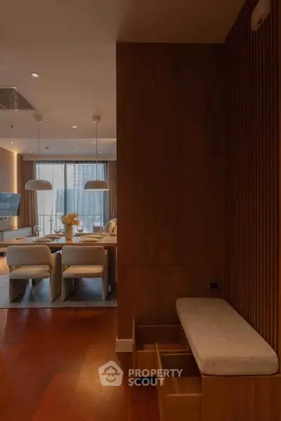Elegant modern living room with dining area, wooden accents, and stylish lighting.