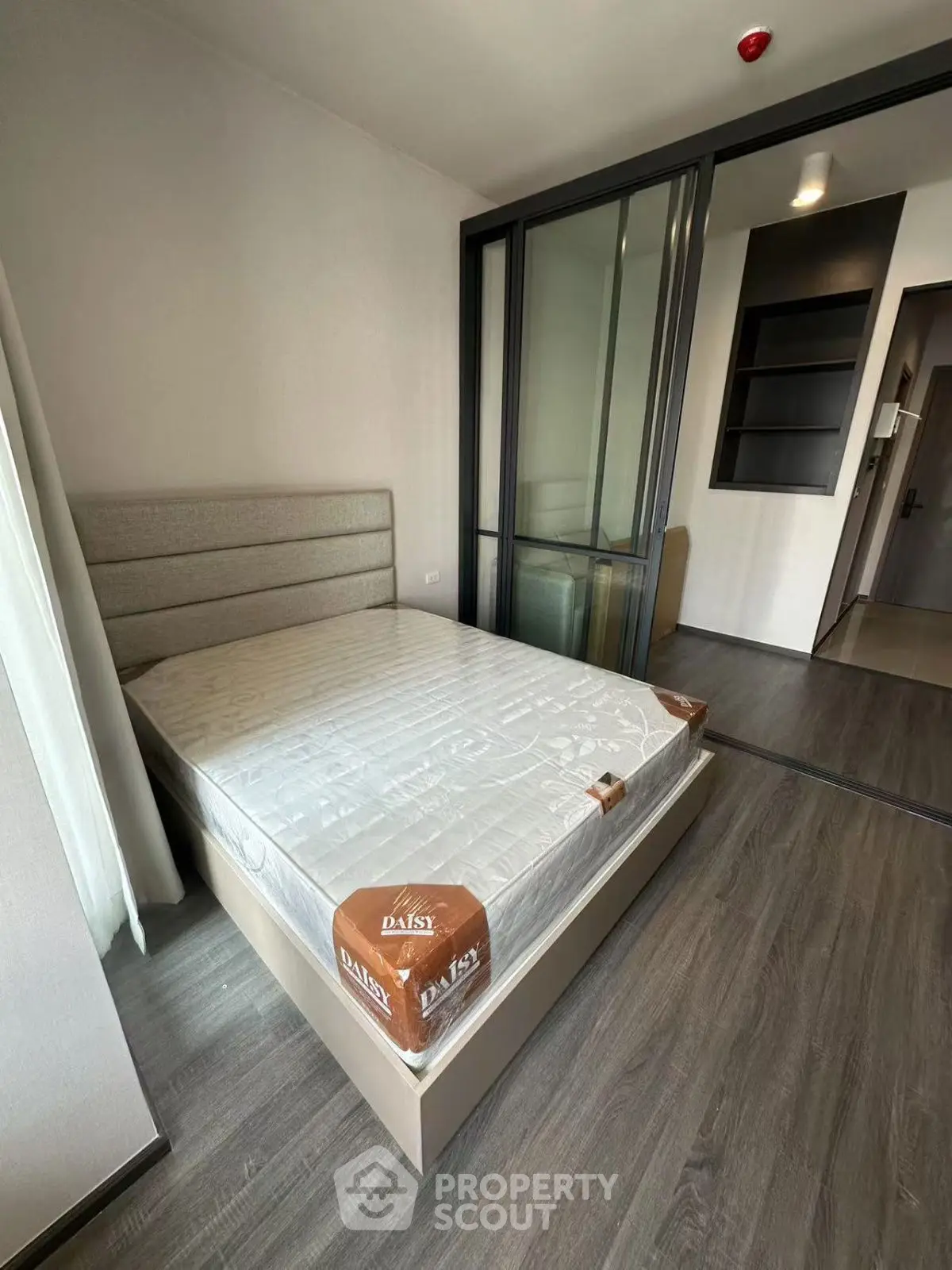 Modern bedroom with sleek design and glass partition in a stylish apartment.