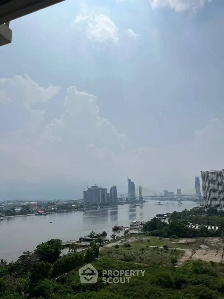 Stunning river view from high-rise apartment with city skyline and lush greenery.