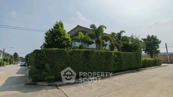 Charming corner house with lush greenery and modern architecture in a serene neighborhood.