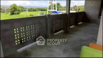 Spacious balcony with scenic countryside view and modern concrete design.