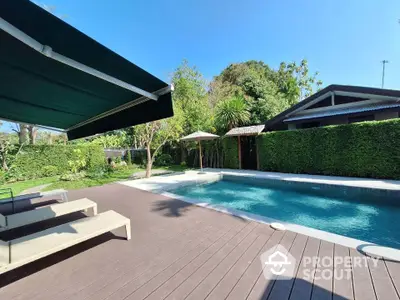 Luxurious outdoor pool area with sun loungers and lush greenery