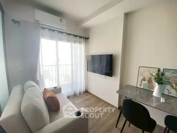 Modern living room with cozy sofa, wall-mounted TV, and stylish decor in bright apartment.