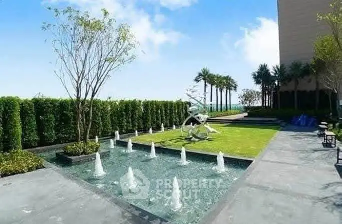 Luxurious outdoor garden with modern water features and lush greenery in a high-end residential complex.