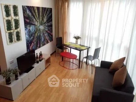 Charming living room with modern decor, large artwork, and natural light from floor-to-ceiling windows.